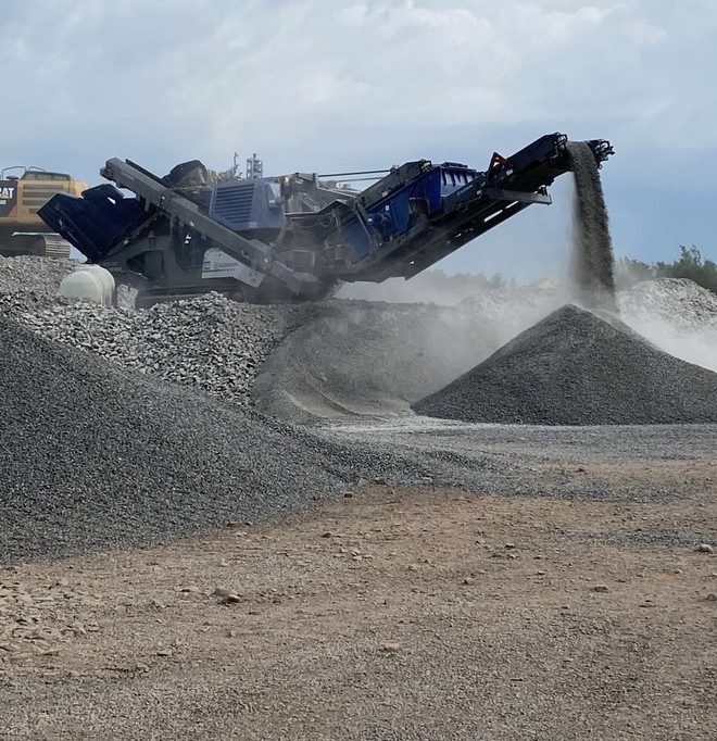 Tracked crusher stockpiling aggregate